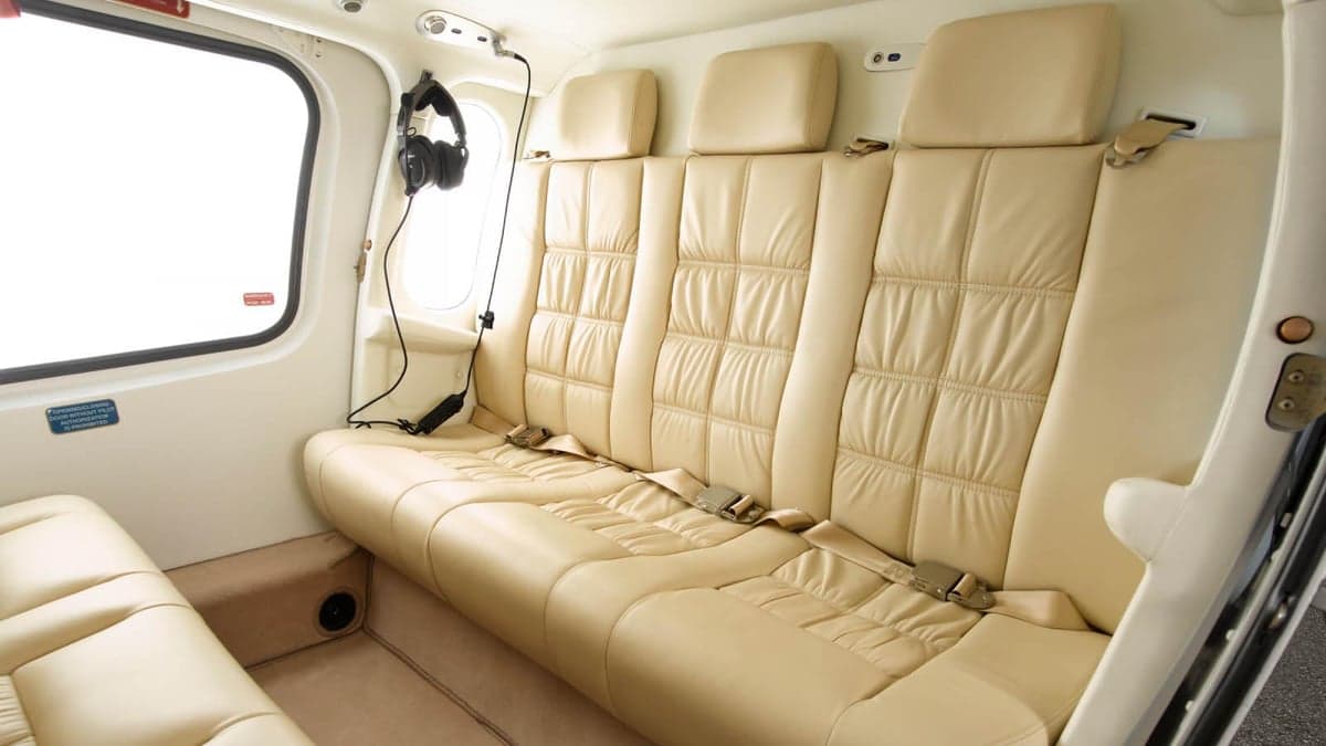 The interior of the AgustaWestland AW119 Koala helicopter features cream-colored leather seats and headphones.