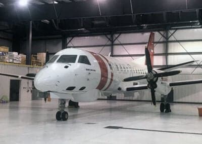 Front view of a Maritime Security Beechcraft 1900 aircraft parked inside a hangar.