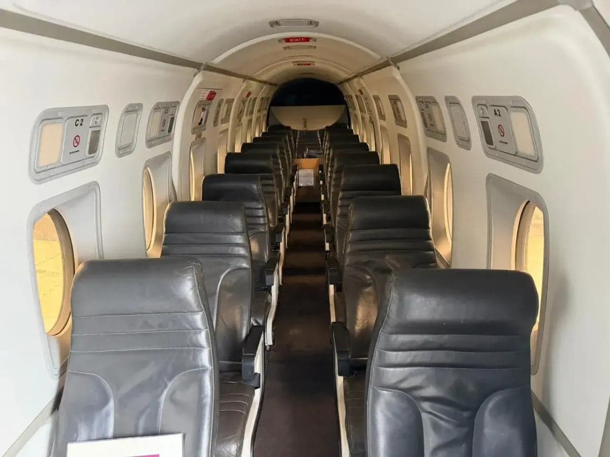 Interior view of the Beechcraft 1900 cabin with black leather seats.