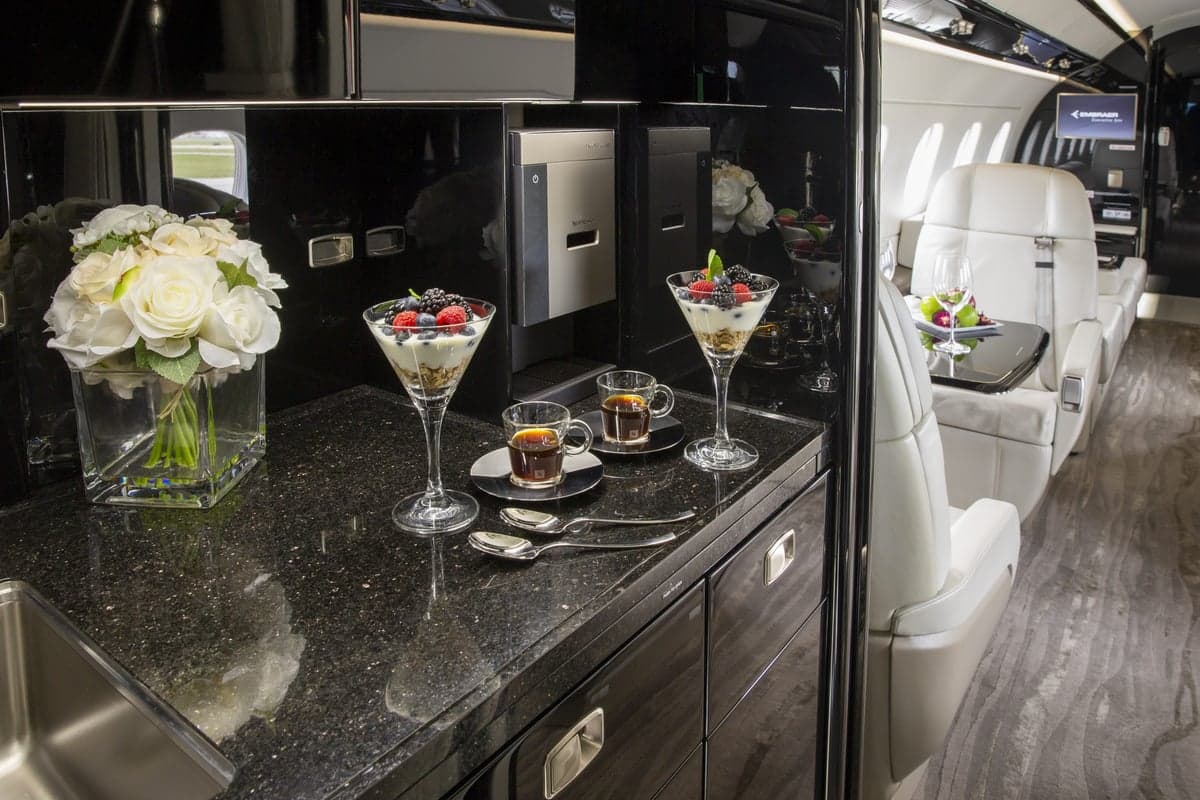 Interior view of the Embraer Legacy 500 cabin with refreshments.