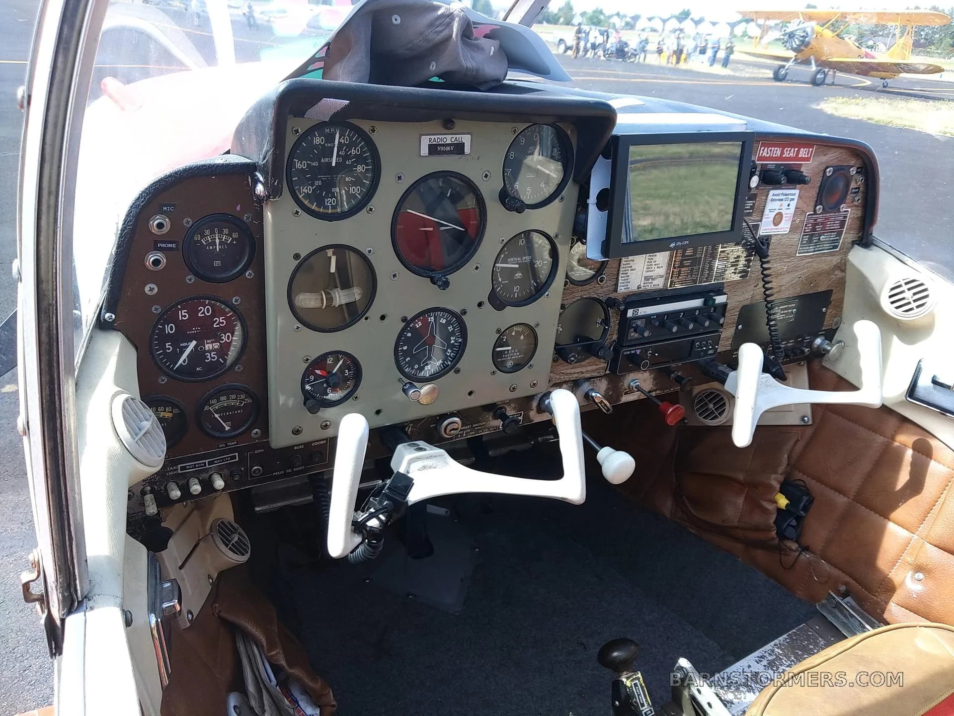 The cockpit features a classic instrument panel with analog gauges and a modern digital display.
