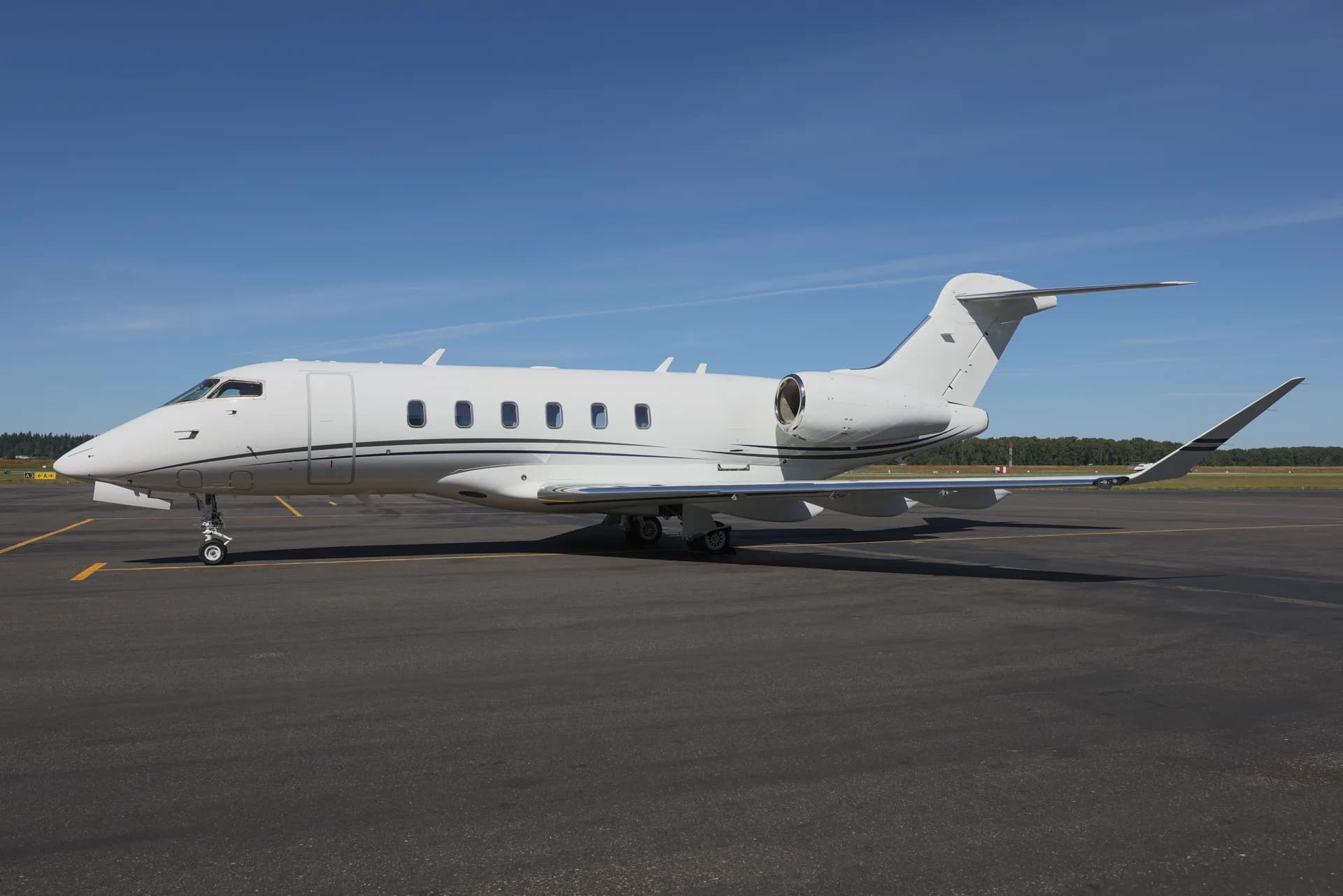 A Challenger aircraft is parked on the tarmac on a sunny day.