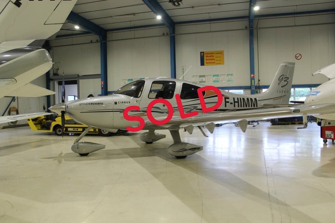 A Cirrus aircraft with registration F-HIMM is parked in a hangar, with a 'SOLD' overlay.