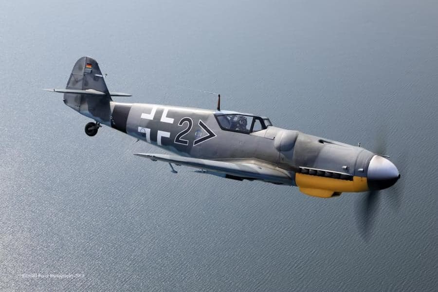 A Messerschmitt Bf 109 flying over the water.