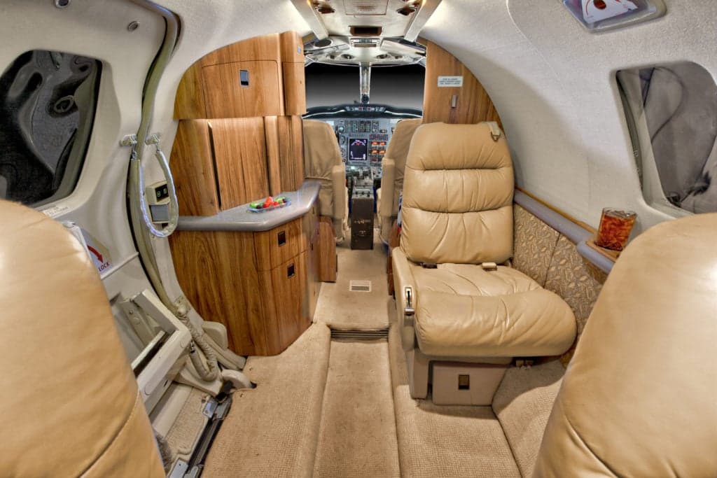 View of the Citation Ultra cabin interior with leather seats and wood accents.