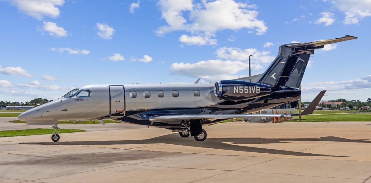 A Phenom 300 aircraft with registration N551VB parked on the tarmac.