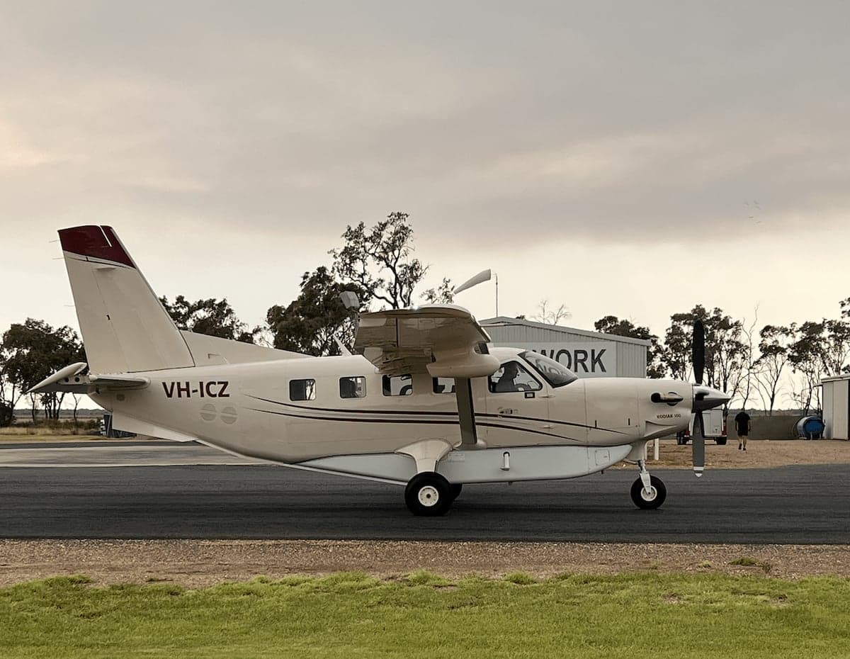 A beige Kodiak 100 aircraft parked on a runway.