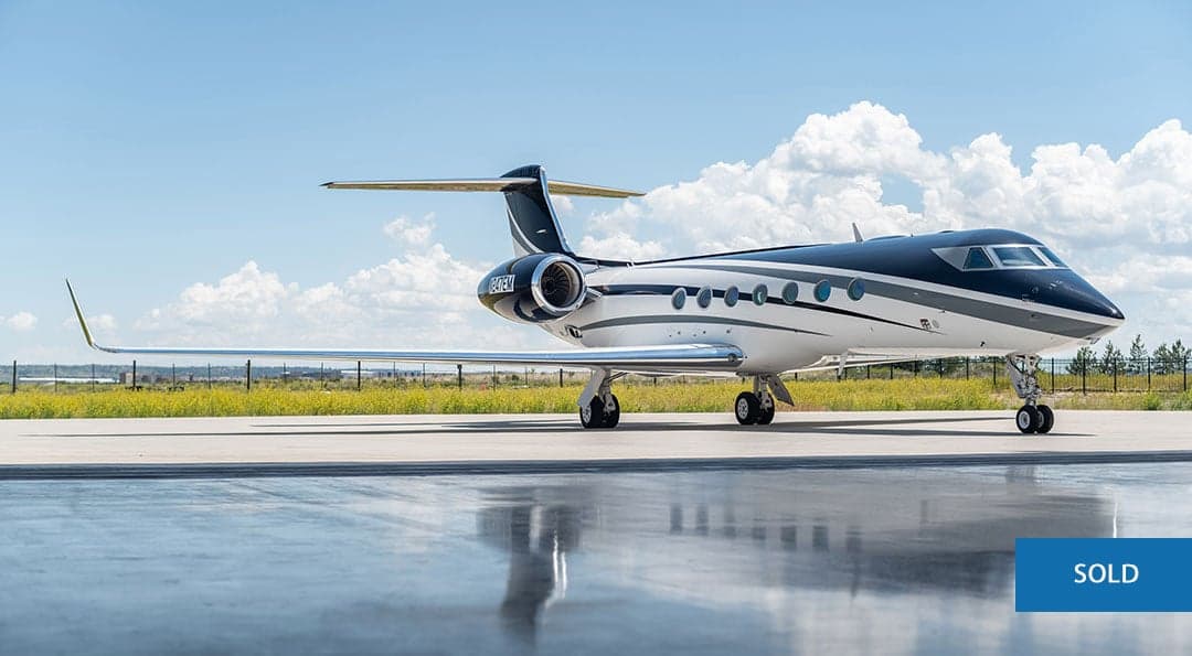 Gulfstream G550 aircraft N247EM on the tarmac with a SOLD overlay.