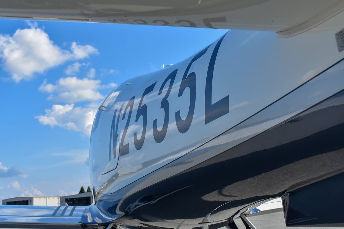 Rear view of a Lancair Columbia 400 aircraft with tail number N2535L on the tarmac.