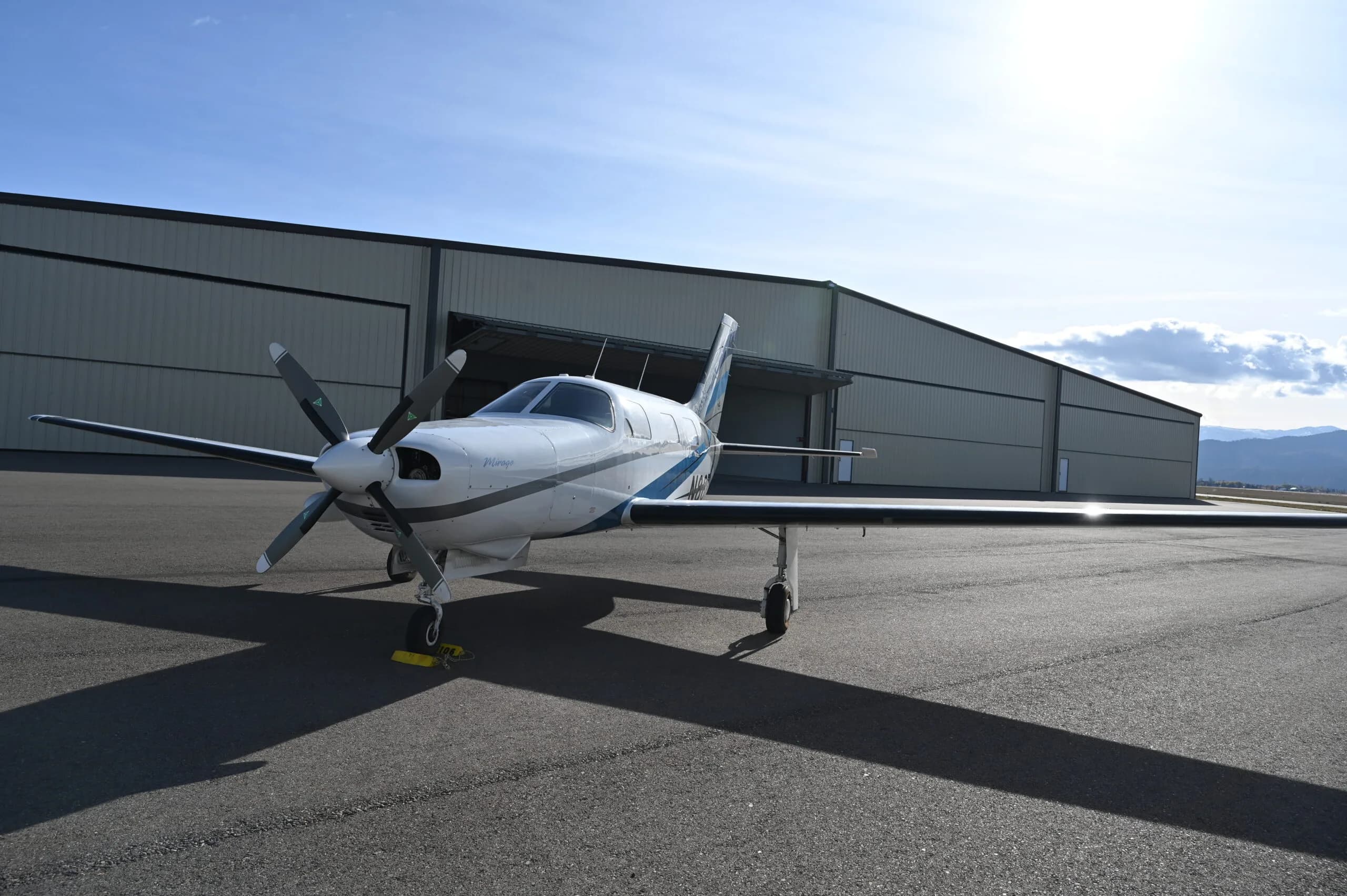 Piper Mirage parked on the tarmac in front of a hangar.