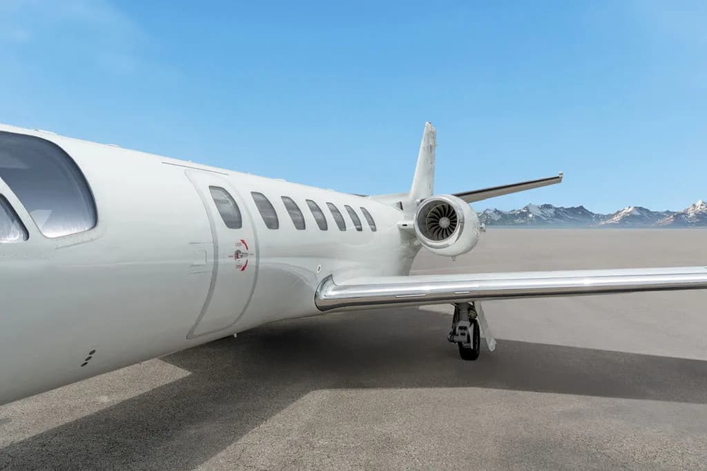 A close-up view of the mid-fuselage and engine of a white Cessna Citation CJ3.