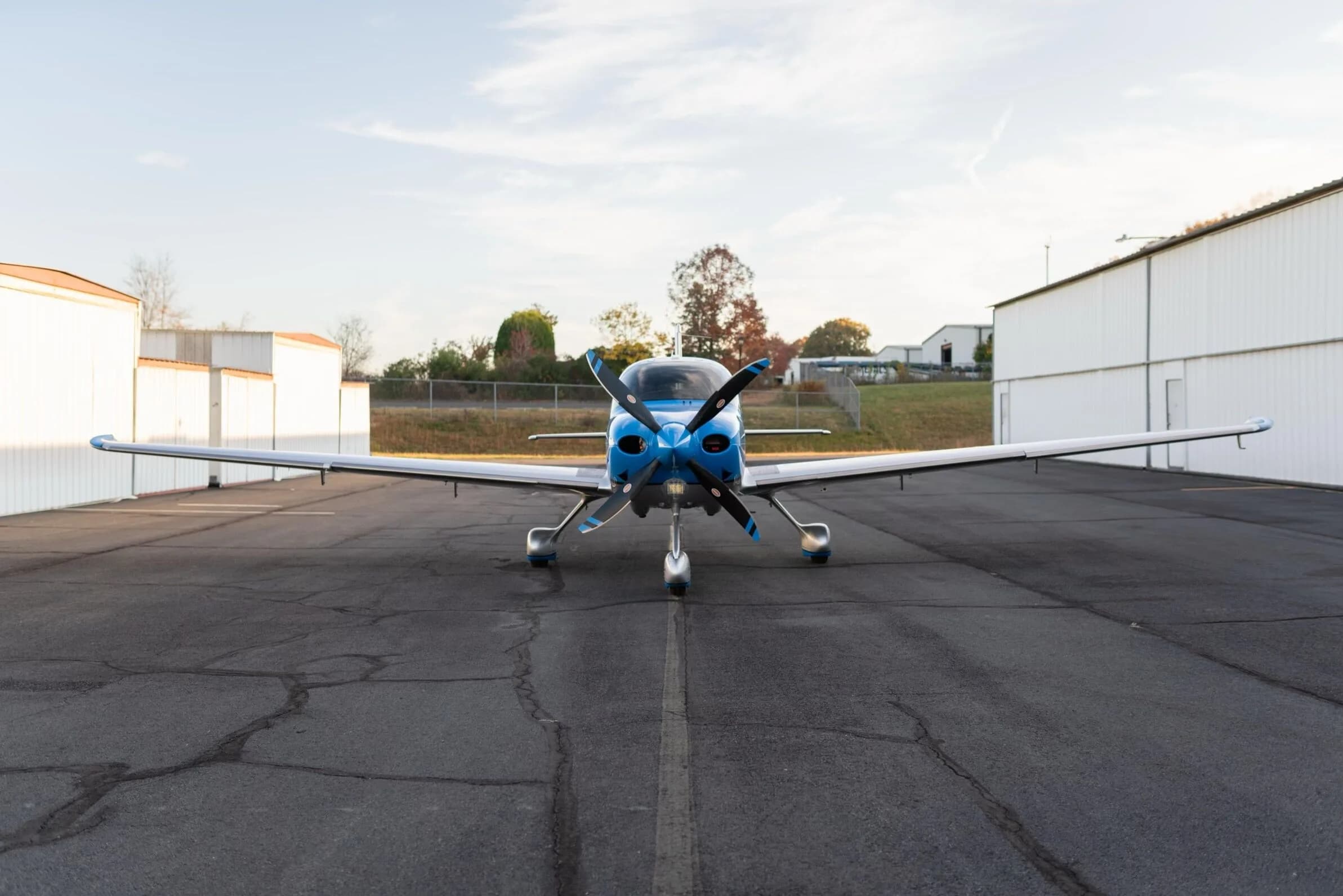A front view of the blue and silver Cirrus SR22T GTS aircraft, registration N79CV, parked on an airfield.