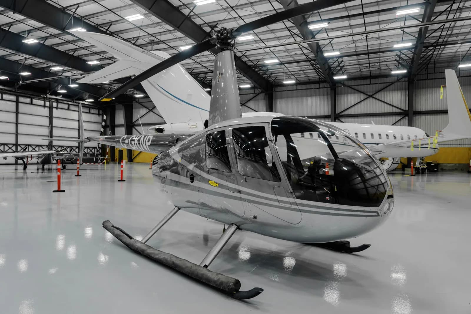 Robinson helicopter C-GKNP parked inside a hangar.