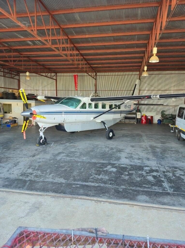 A Cessna Caravan aircraft is parked inside a hangar.