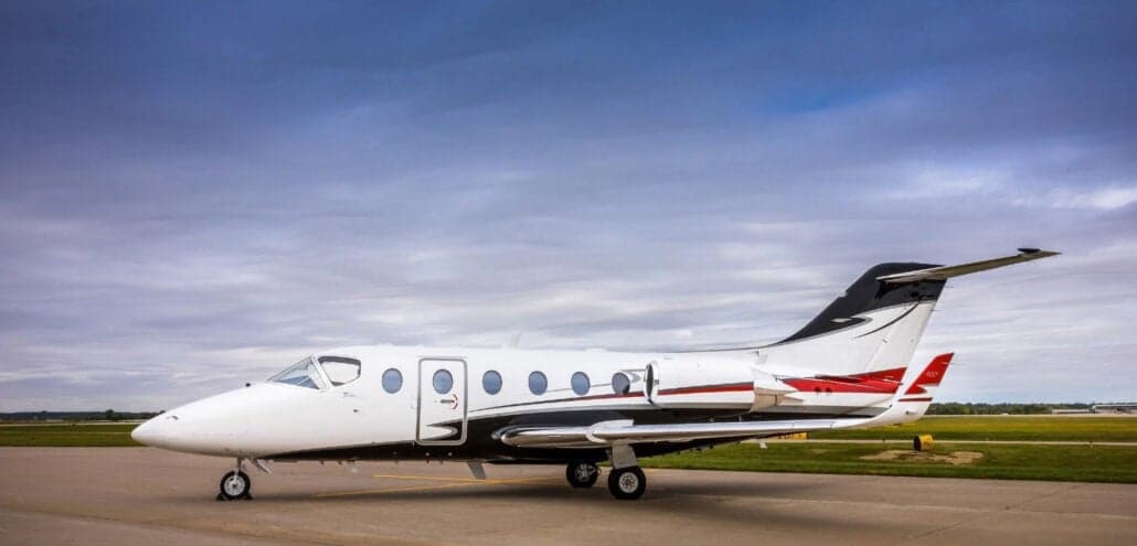 Side view of a white and black jet aircraft on the tarmac.