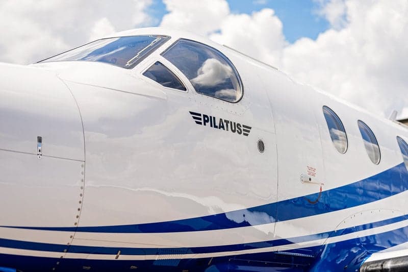 Close-up of the cockpit area of a Pilatus PC-12 aircraft with the Pilatus logo.