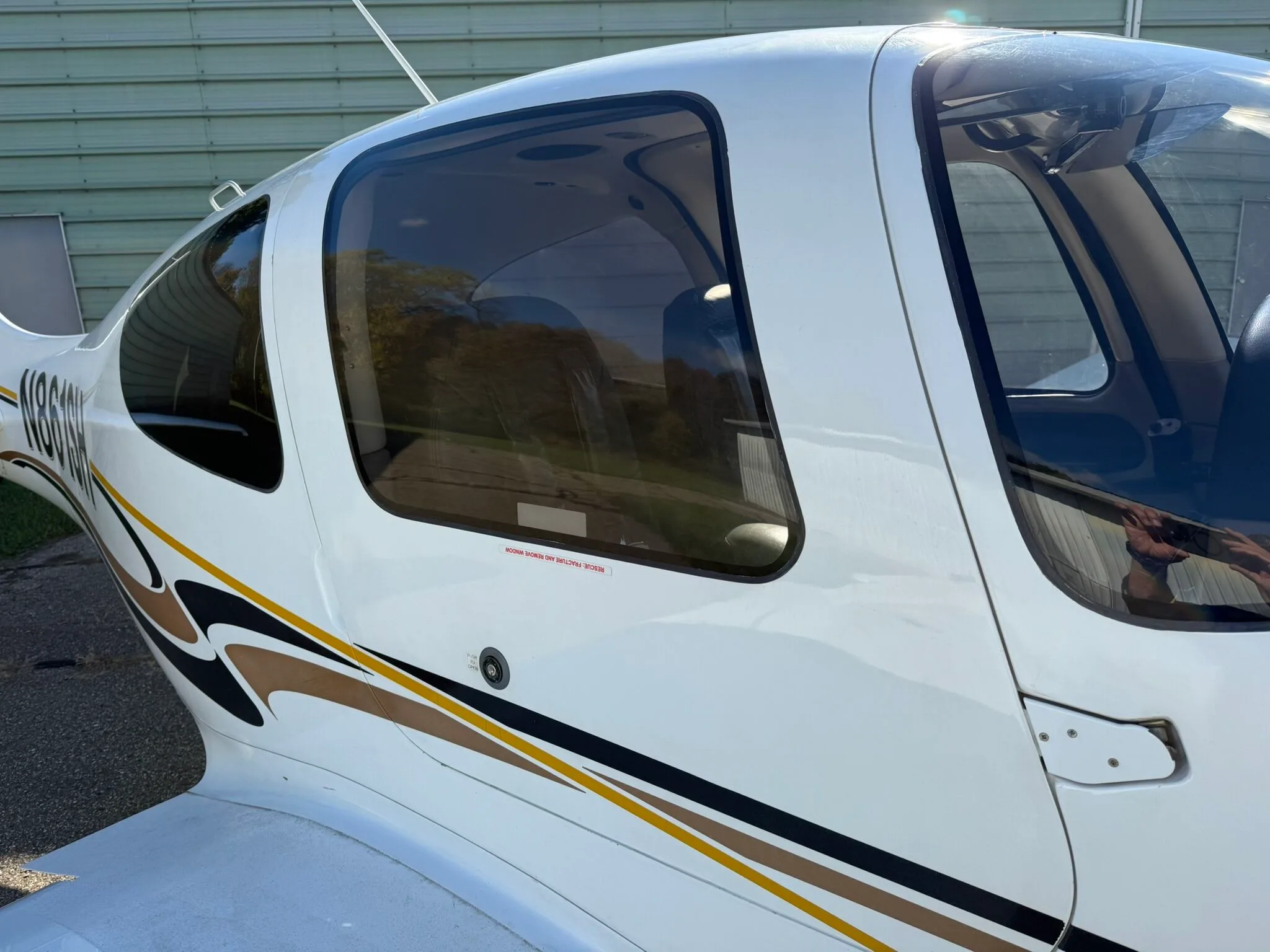 A close-up view of the tinted windows on the side of the white Cirrus SR20 fuselage.