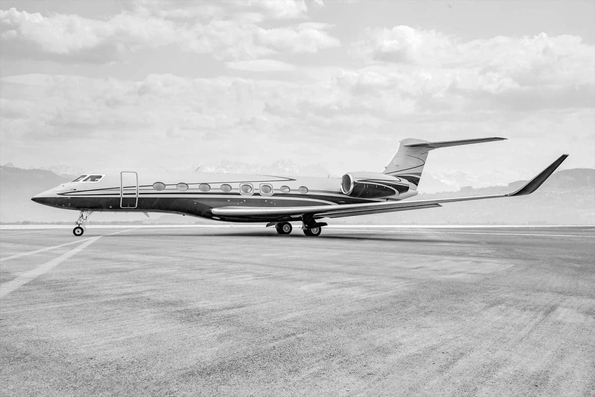 A Gulfstream business jet on the tarmac in black and white.