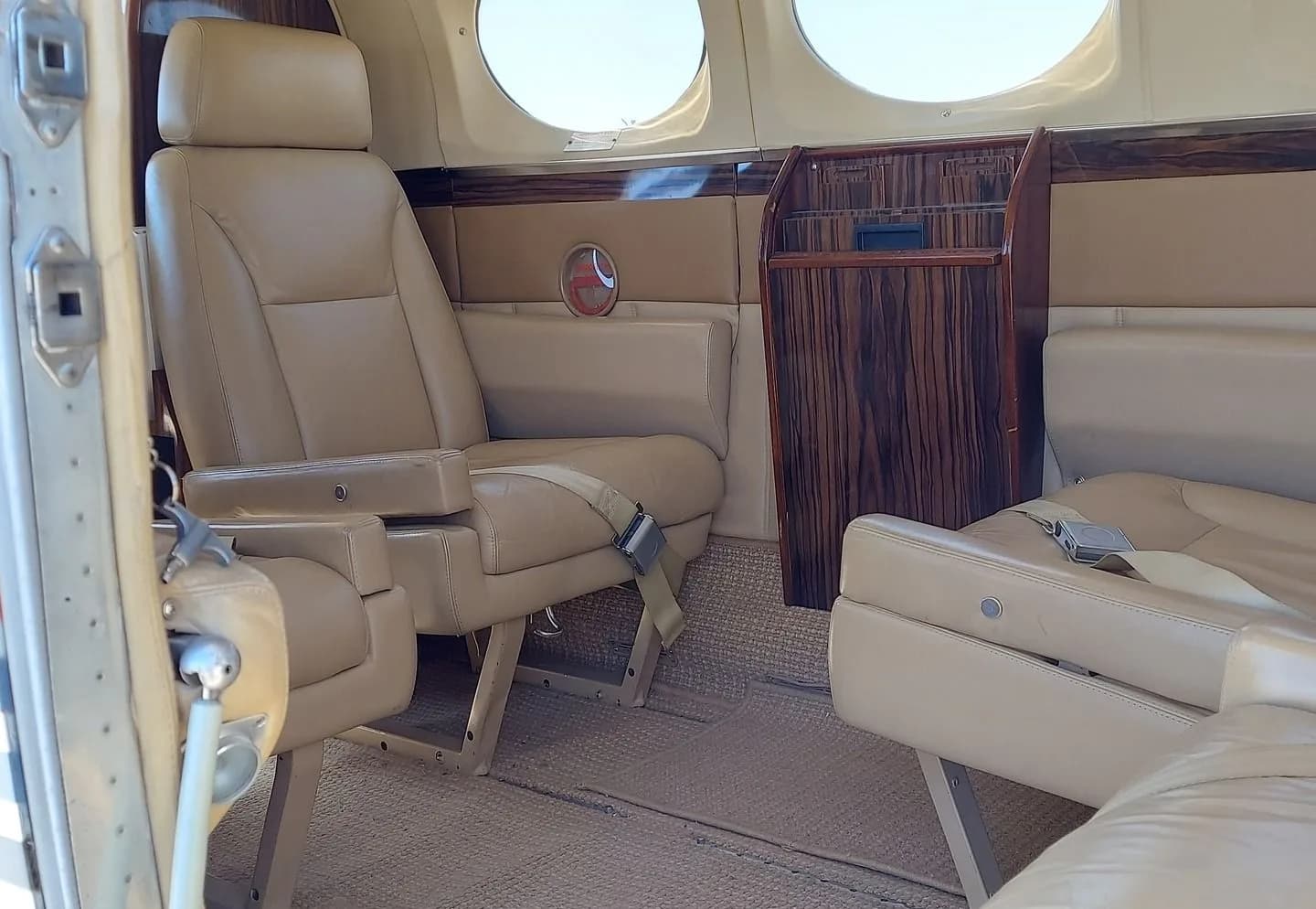 Interior of a Cessna 414 aircraft with tan leather seats and wood trim.