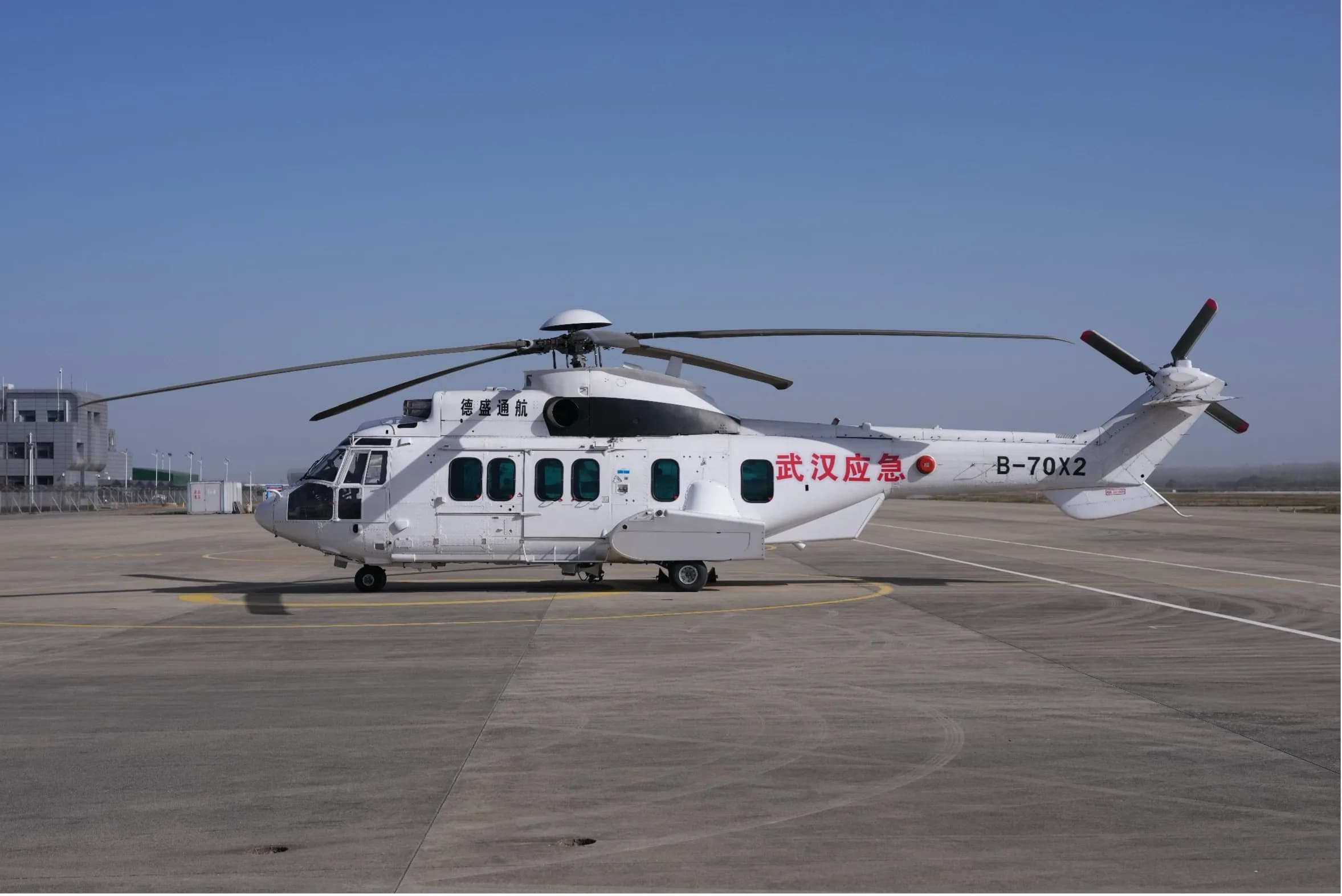 A side view of a white Airbus Helicopters H225 Super Puma on the tarmac.