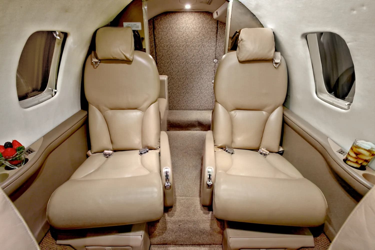 A view of the interior of a jet with tan leather seats.