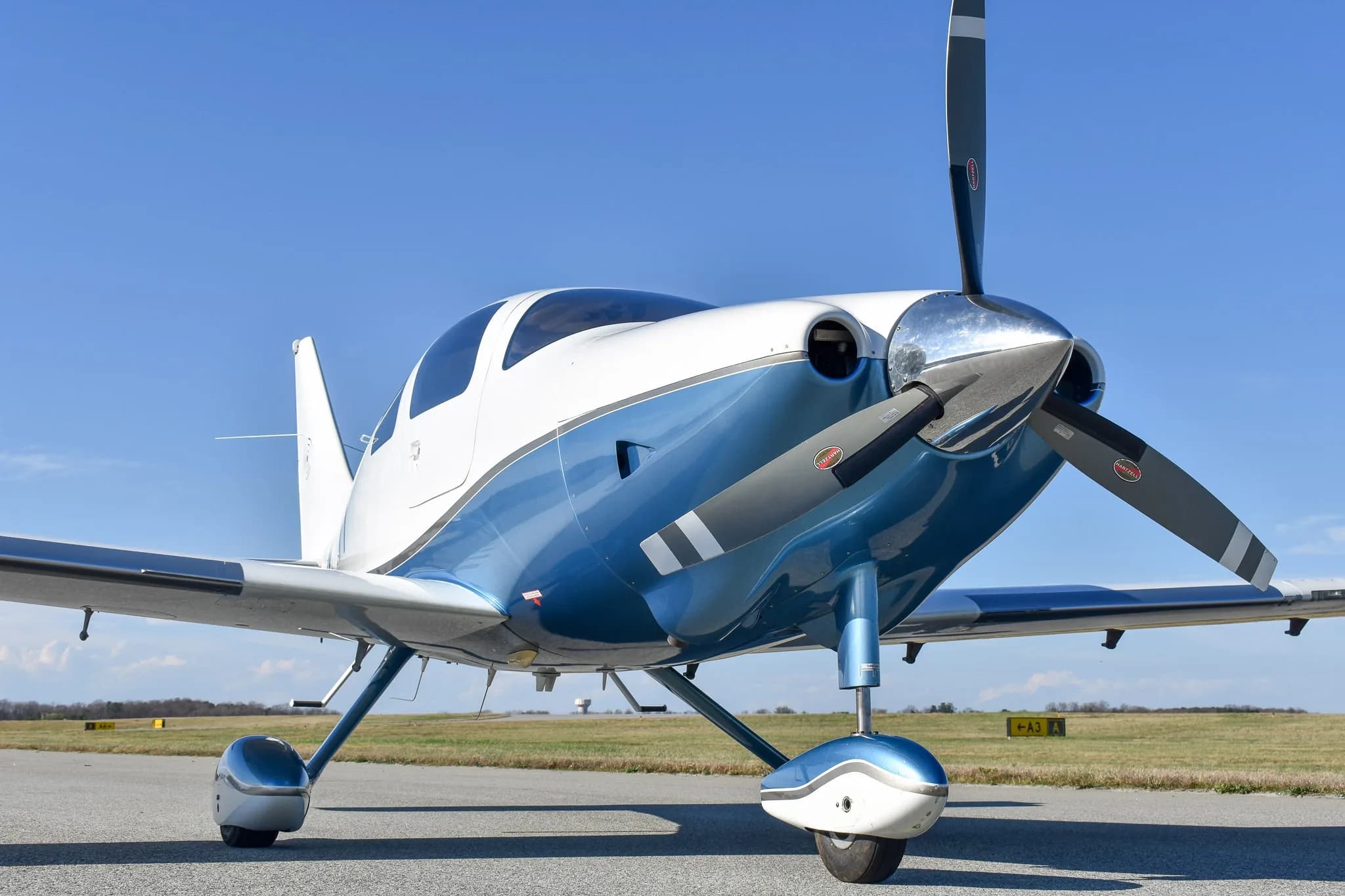A close-up front view of the white and blue single-engine aircraft, N2547T, showing its propeller and landing gear.