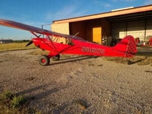 A red aircraft with tail number N509TW is parked outside.