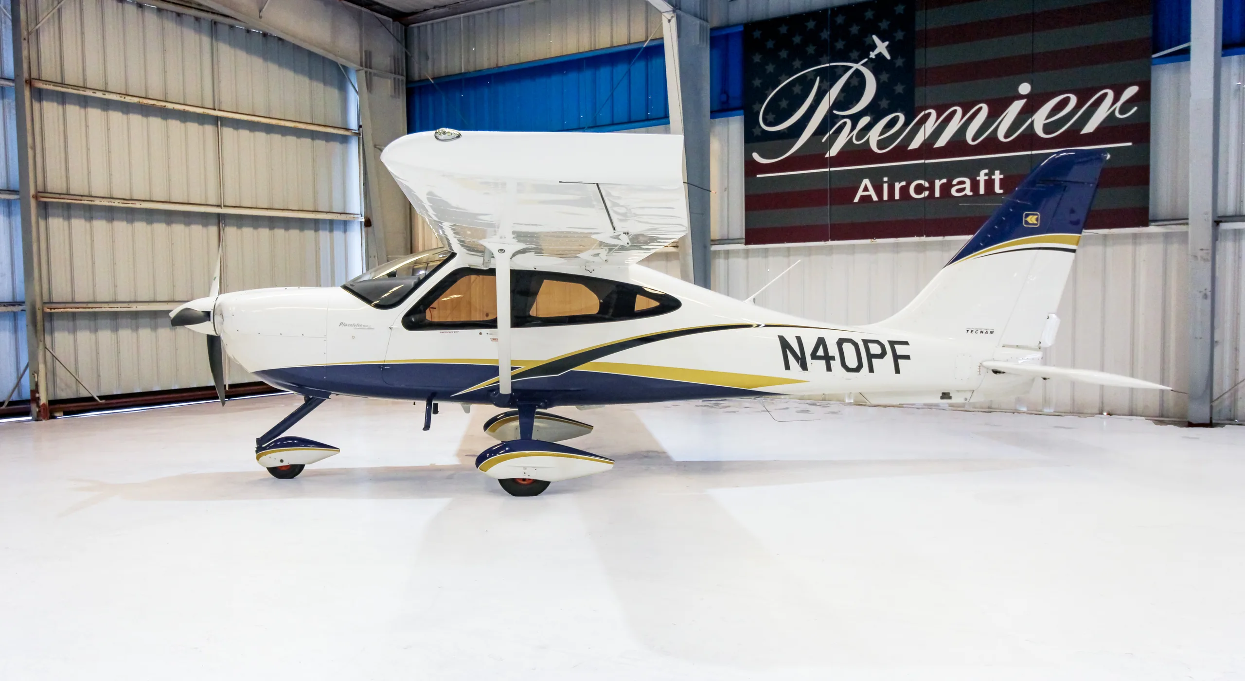 A Techman aircraft with registration N40PF is parked in a hangar with a Premier Aircraft banner in the background.