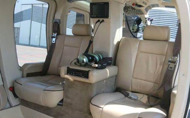 Interior view of a helicopter cabin with tan leather seats.