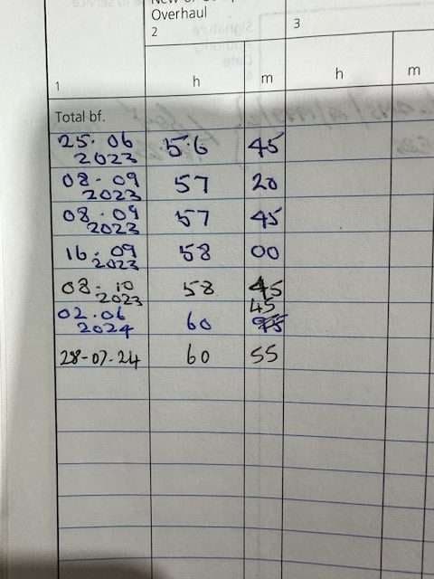 Close-up of a logbook page with handwritten flight time entries.