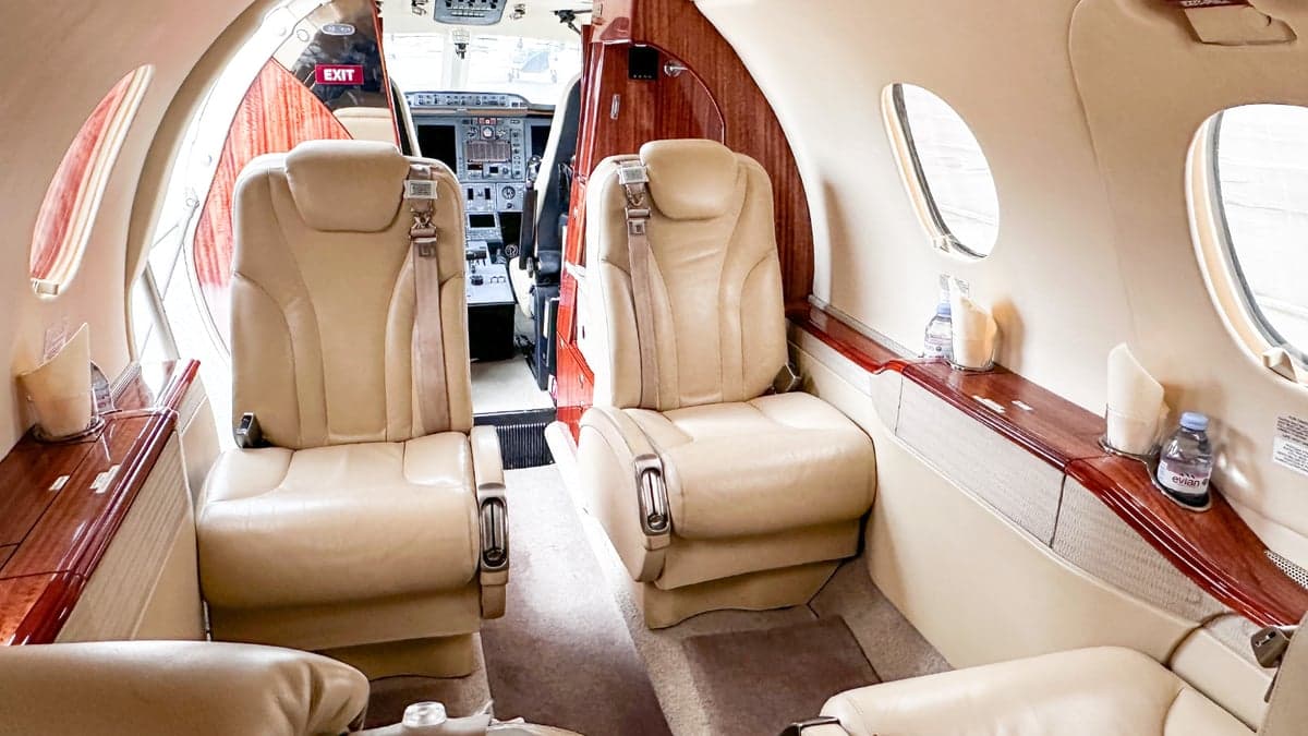 Aircraft interior with leather seats and wood trim.