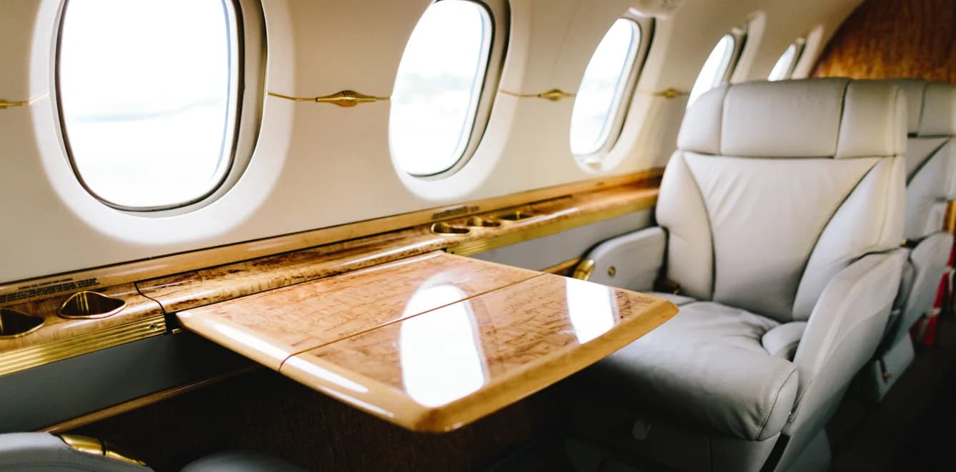 Close-up of the aircraft's interior with a fold-out table and leather seats.