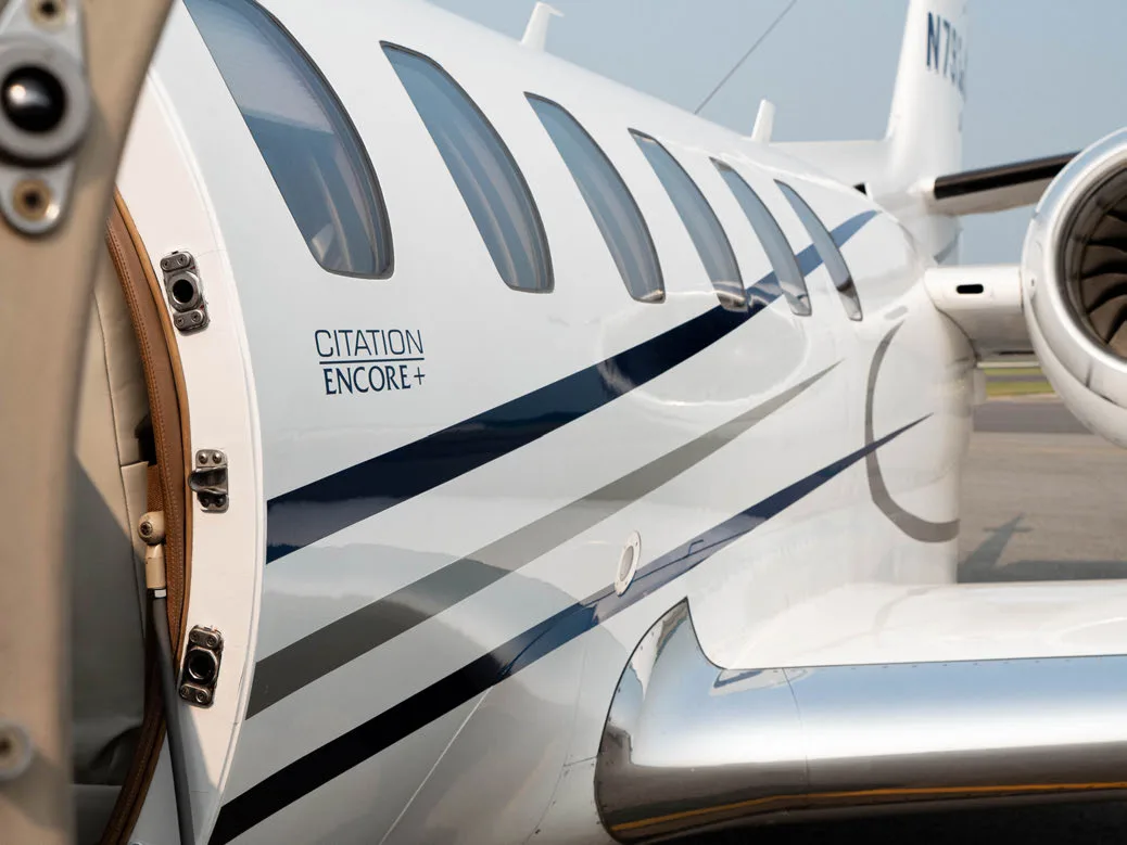 Close-up of the Citation Encore+ aircraft fuselage with an open door.