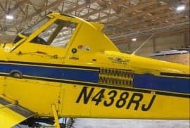 Close-up of the side of a yellow and blue agricultural aircraft with the tail number N438RJ.