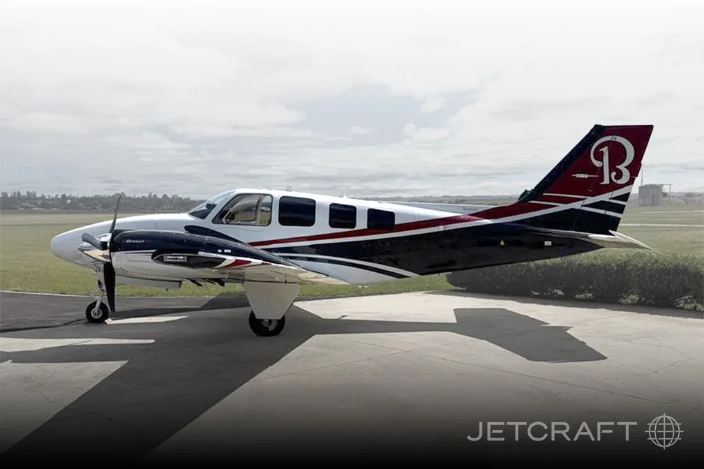 A Beechcraft Baron aircraft is parked on the tarmac.