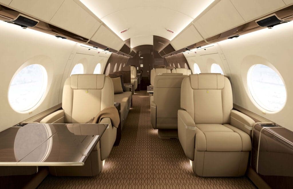 Interior view of a private jet cabin with tan leather seats.