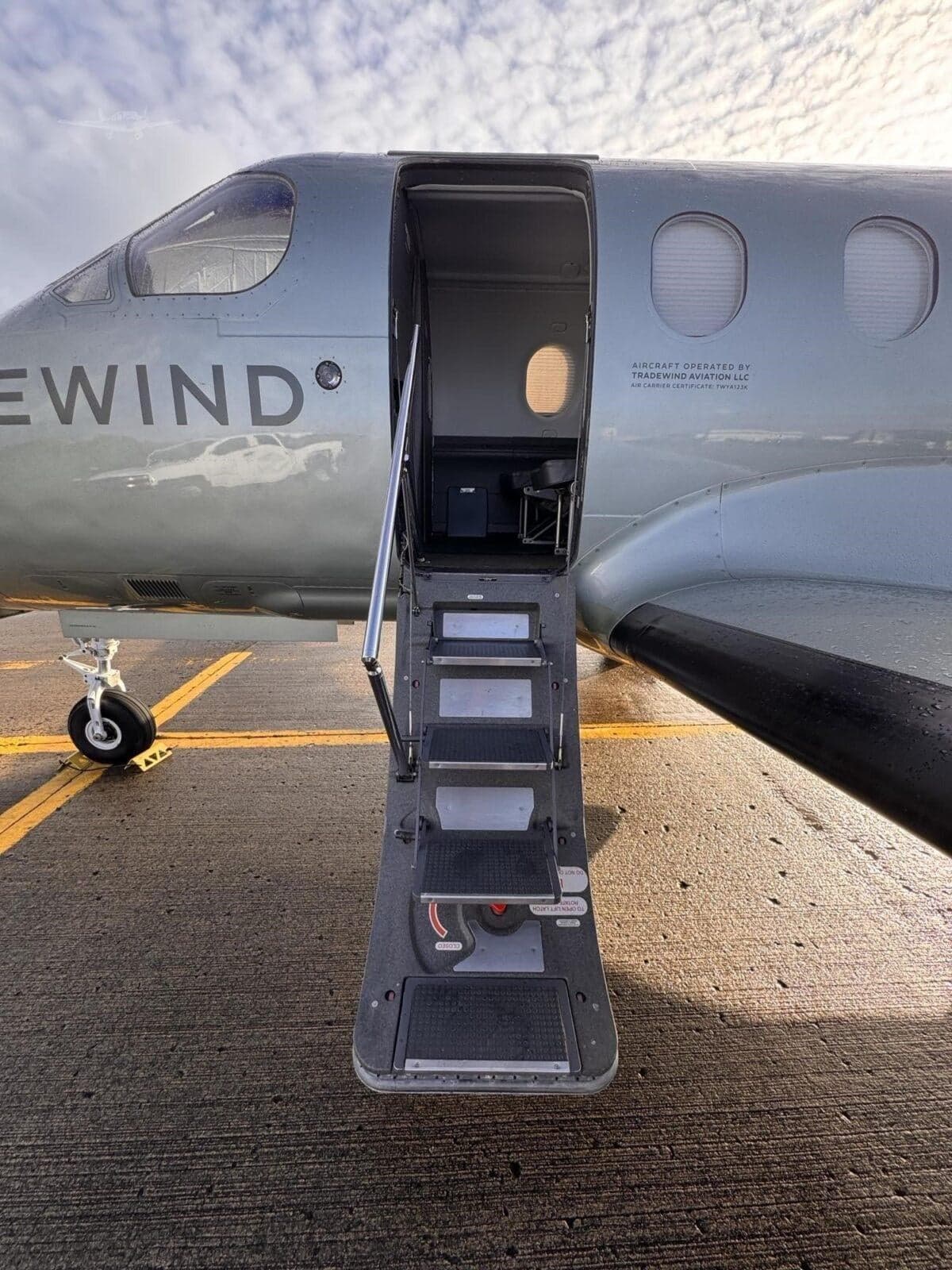 Close-up of the Tradewind PC-12 aircraft door and steps, showing the aircraft's branding.