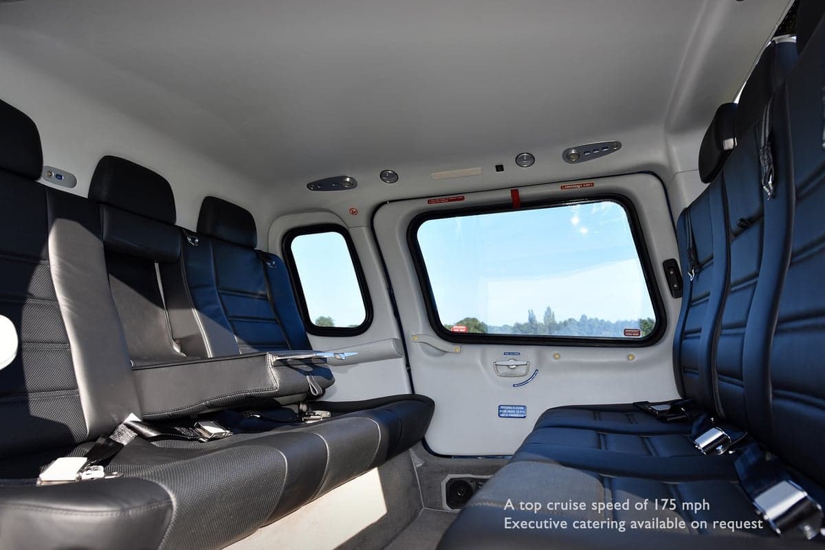 The helicopter's interior features black leather seats and a small table.