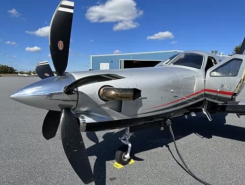 Close-up of the front of a TBM 930 aircraft with the door open.