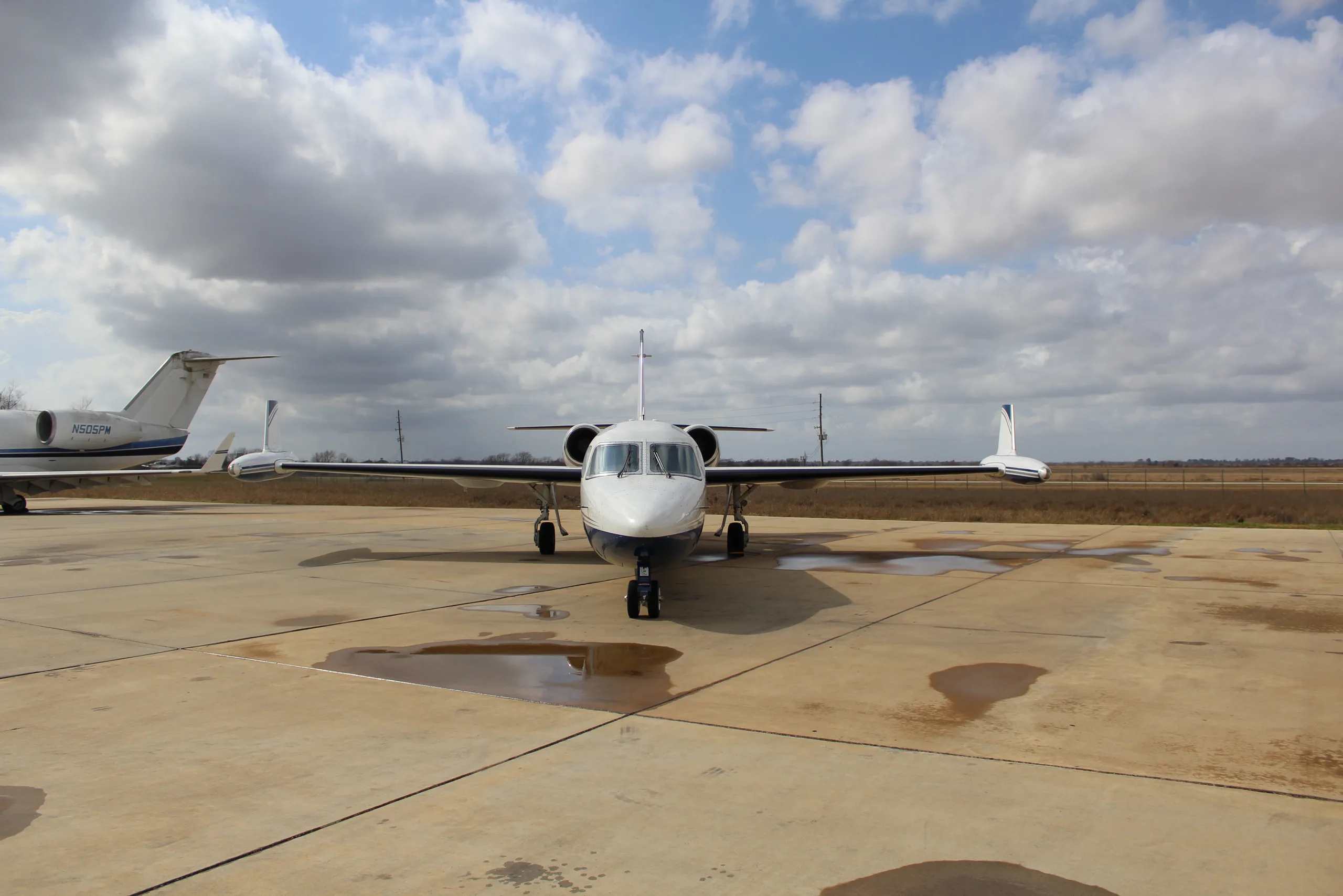 Front view of a Westwind Astra SPX aircraft with registration N241CT parked on the tarmac under a cloudy sky.