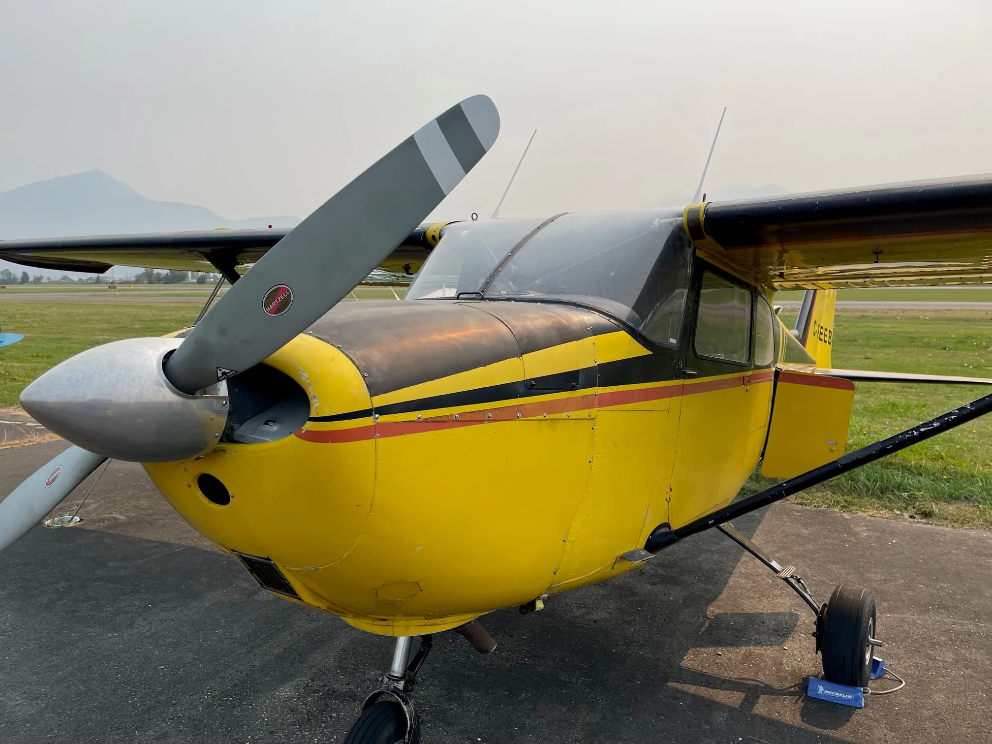 Close-up of the front of a yellow and black Cessna aircraft.