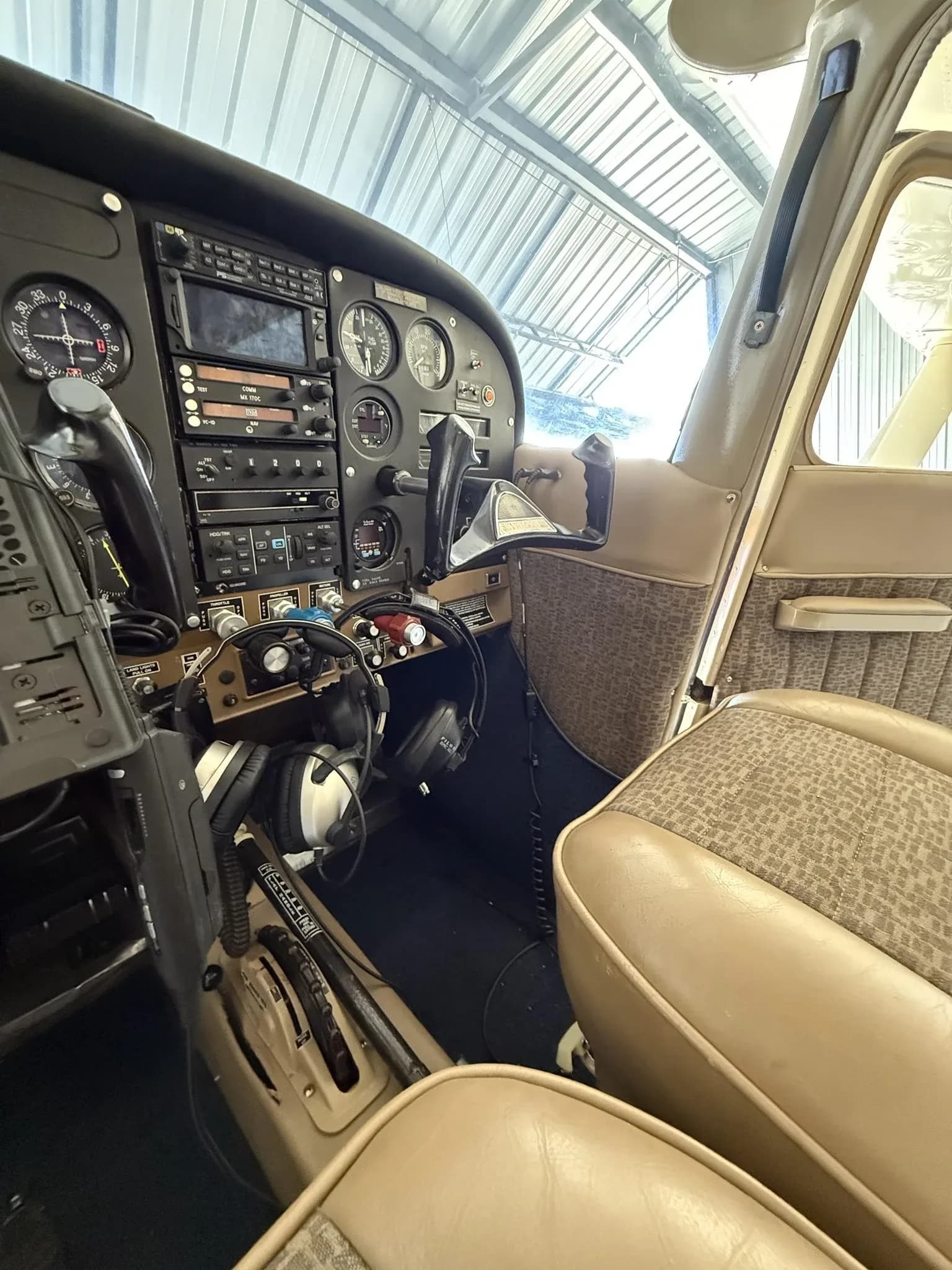 View of the aircraft's cockpit showing the instrument panel, controls, and pilot's seat.
