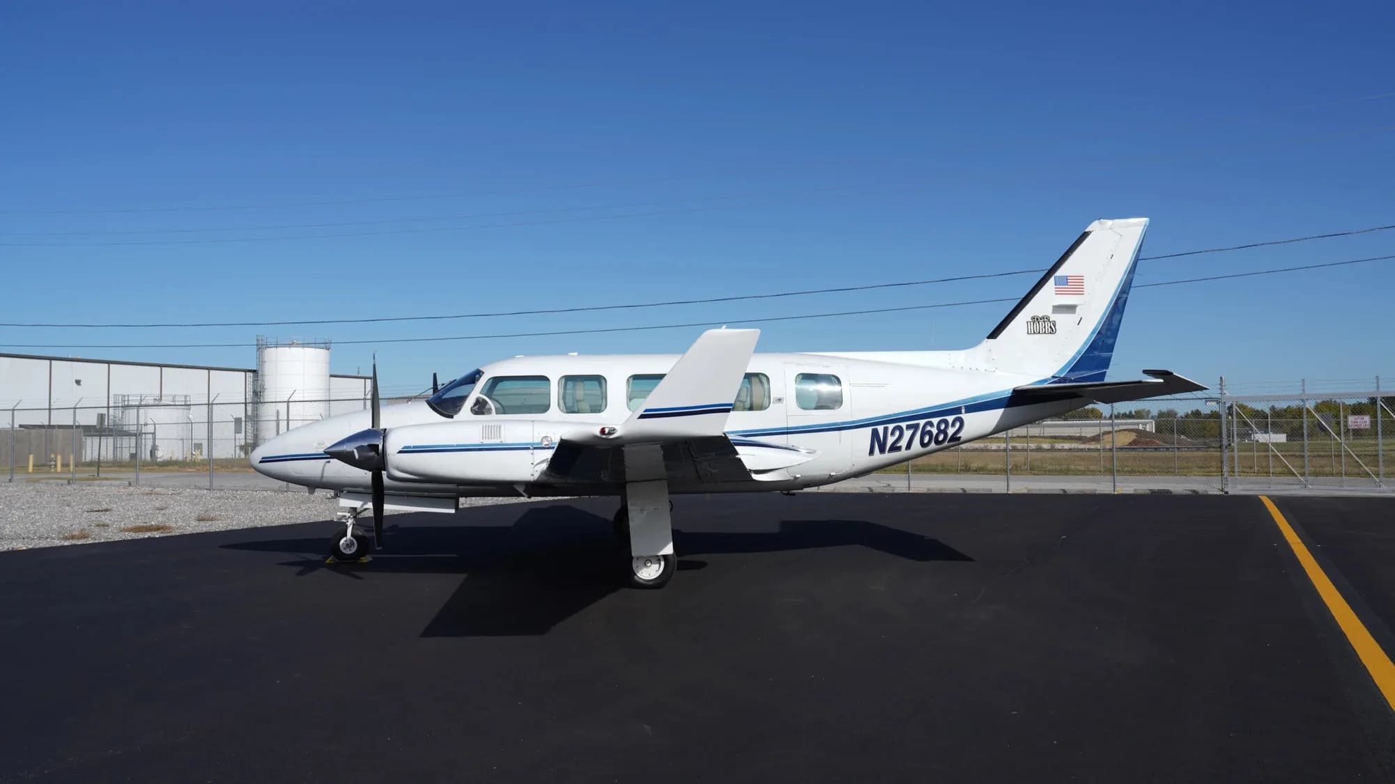 Side view of the white and blue twin-engine aircraft with tail number N27682.
