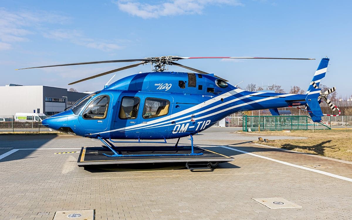 A 2012 Bell 429 helicopter with blue and white paint scheme on a platform.