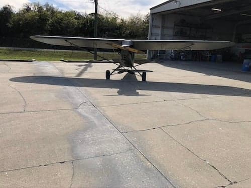 Olive drab aircraft parked in front of a hangar.