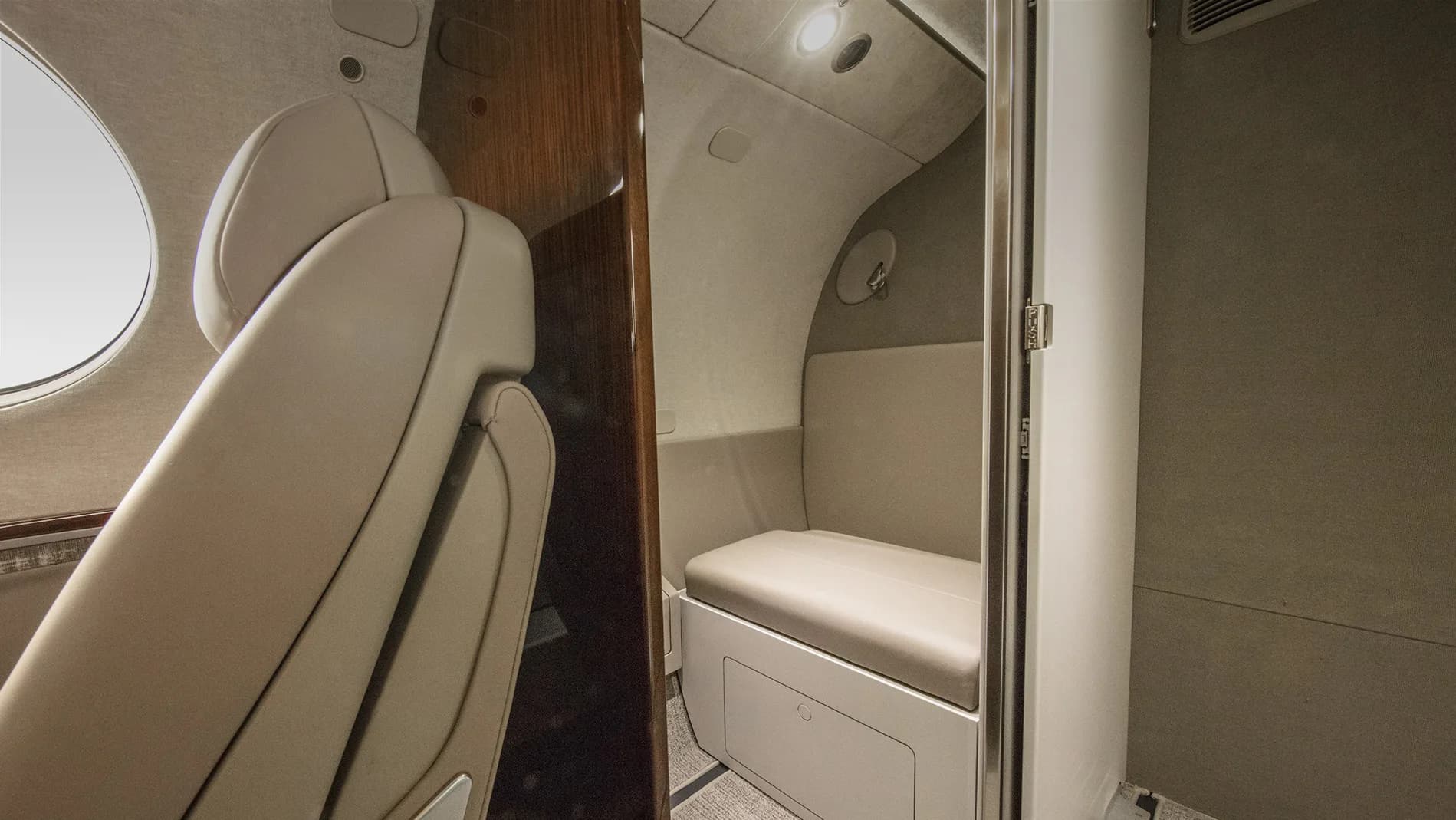 View of the aircraft interior with leather seats and a lavatory.