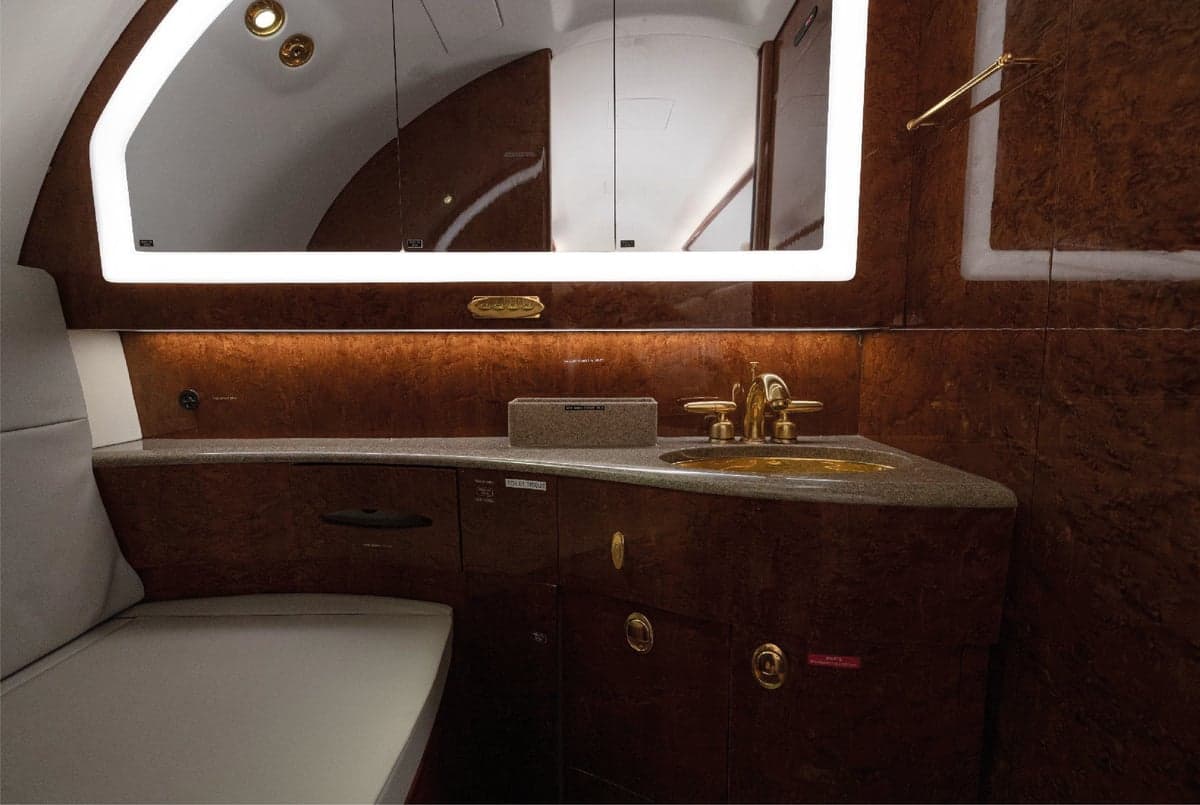 Aircraft lavatory with wood trim and a sink.