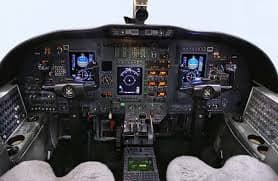 The cockpit of an aircraft with multiple displays and controls.