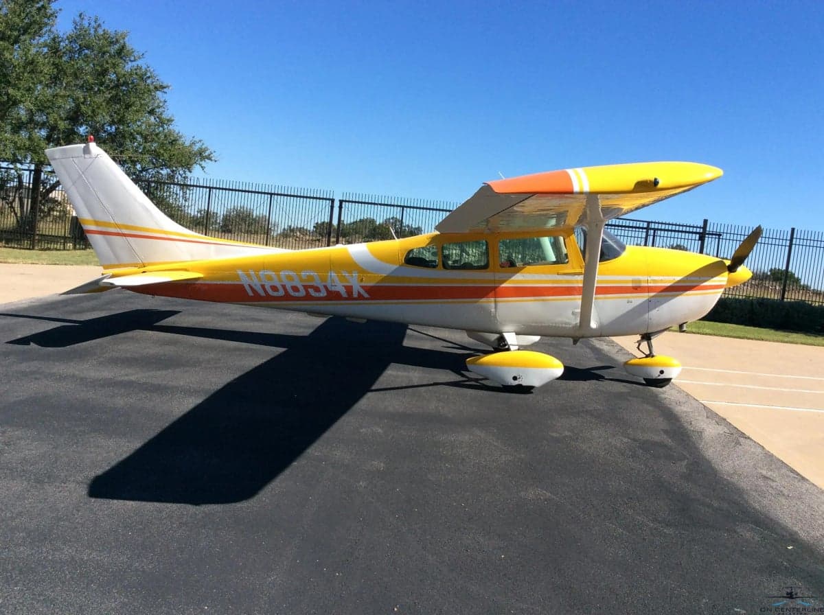 N8834X Cessna 172 Skyhawk with yellow and orange paint scheme, side view.