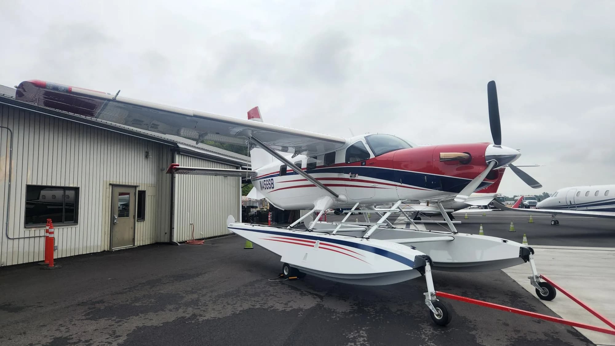 A Quest Kodiak 100 on floats parked near a building.